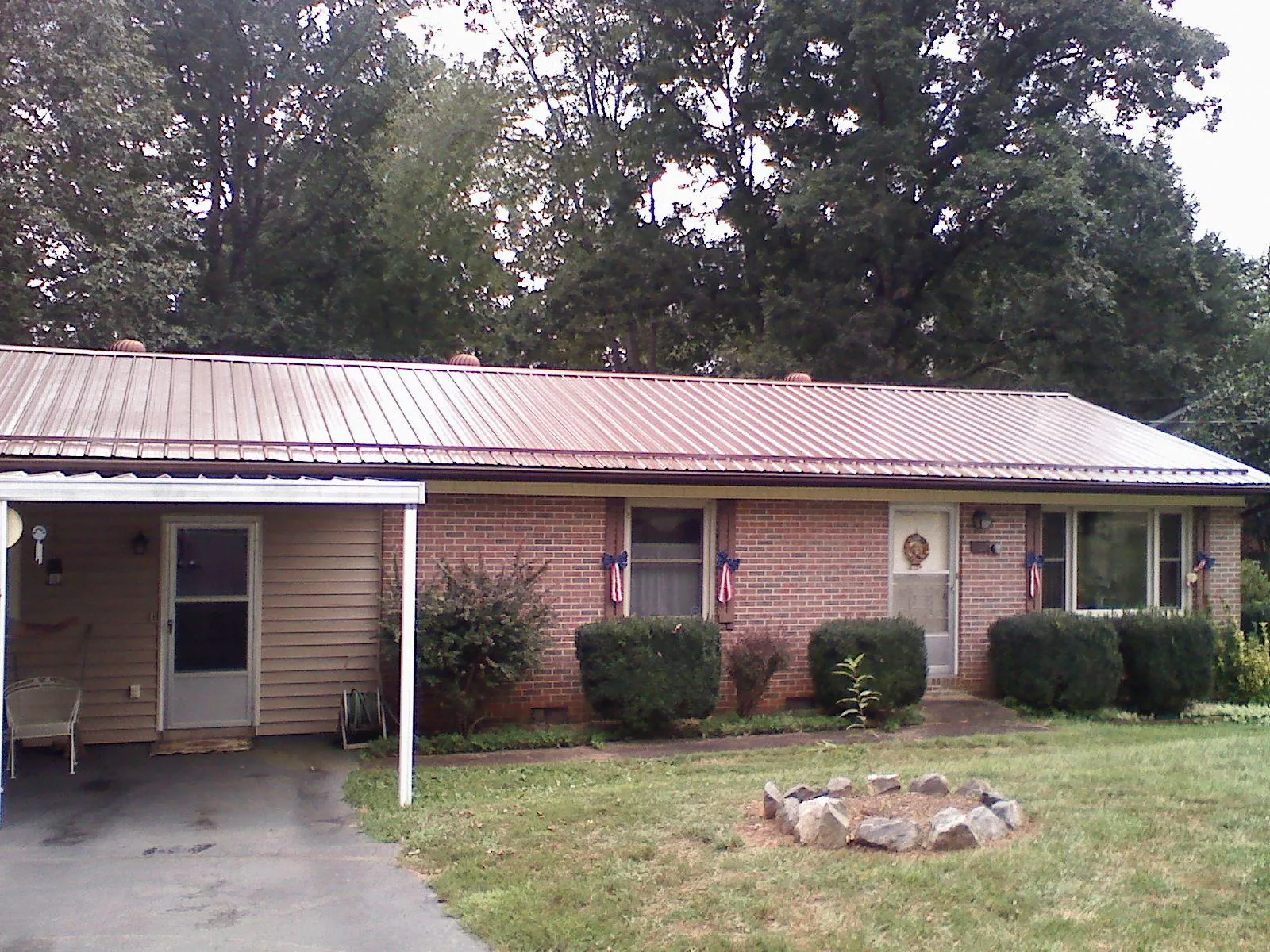 Bronze metal roof and carport on a brick ranch home — Roof Repair work by our crew in Spring Lake